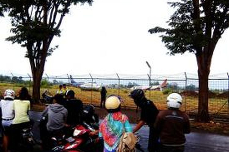Puluhan warga masyarakat saat menonton pesawat Batik Air yang tergelincir dari kejahuan
