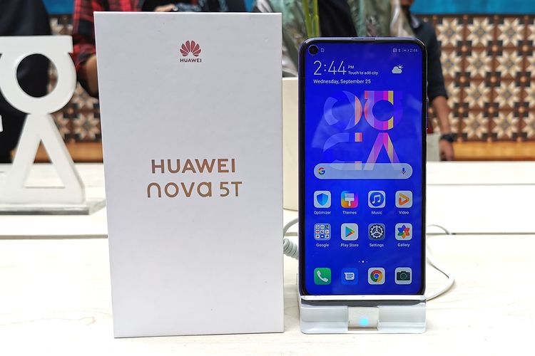 Huawei Nova 5T dan kotak kemasannya yang berwarna dasar putih.