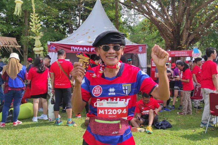 Triono memamerkan medali finisher Tilik Candi Borobudur Marathon 2022. Triono yang sudah berusia 64 tahun mengikuti lomba Tilik Candi Borobudur Marathon 2022 yang digelar pada Minggu (13/11/2022) di Taman Lumbini, Candi Borobudur, Magelang, Jawa Tengah.
