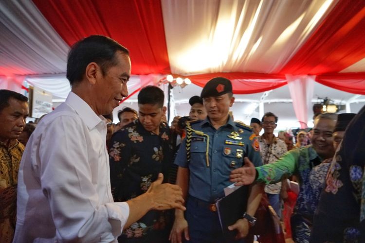 Presiden Joko Widodo bersalaman dengan seorang warga saat penyerahan sertifikat tanah untuk rakyat di Simpang Lima, Semarang, Jawa Tengah, Sabtu (23/12/2017).
