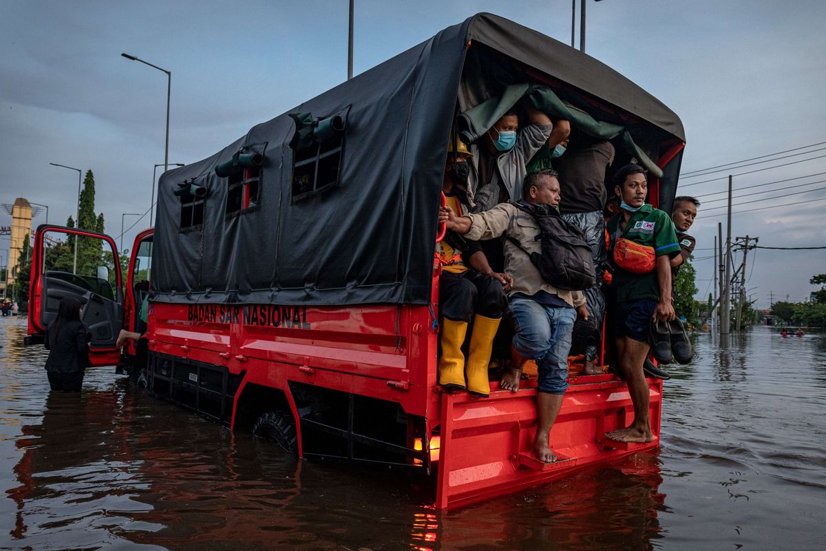 Sejumlah pekerja pelabuhan menumpang truk evakuasi Basarnas untuk menembus banjir limpasan air laut ke daratan atau rob yang merendam kawasan Pelabuhan Tanjung Emas Semarang, Jawa Tengah, Senin (23/5/2022).  Banjir rob dengan ketinggian bervariasi hingga mencapai 1,5 meter itu disebabkan oleh tingginya pasang air laut serta adanya tanggul yang jebol di kawasan tersebut.