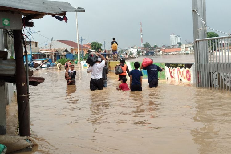 Warga kampung pulo menengok rumah mereka yang terendam, Selasa (6/2/2018) akibat banjir kali Ciliwung