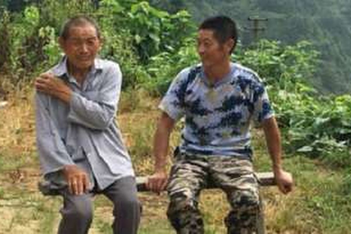 Xiong Jiagen (43) memilih tetap tinggal di desanya karena berbagai alasan, salah satunya adalah untuk merawat pamannya yang sudah renta.
