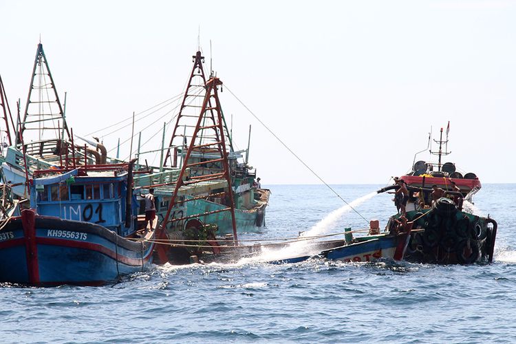 Sejumlah anak buah kapal bantu menyemprotkan air menggunakan mesin pompa ke dalam kapal nelayan Vietnam saat penenggelaman di Pulau Datuk, Kabupaten Mempawah, Kalimantan Barat, Sabtu (4/5/2019). Kementerian Kelautan dan Perikanan menenggelamkan 13 dari 51 kapal nelayan asing asal Vietnam yang ditangkap karena mencuri ikan di Perairan Indonesia.