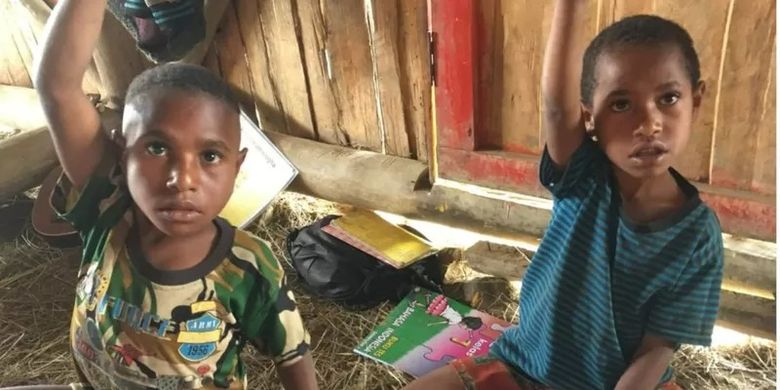 Dua anak asal Kampung Kosarek, Papua mengikuti pelajaran di Mome Lemnep Ae, satu-satunya sekolah alternatif yang ada di kampung mereka.