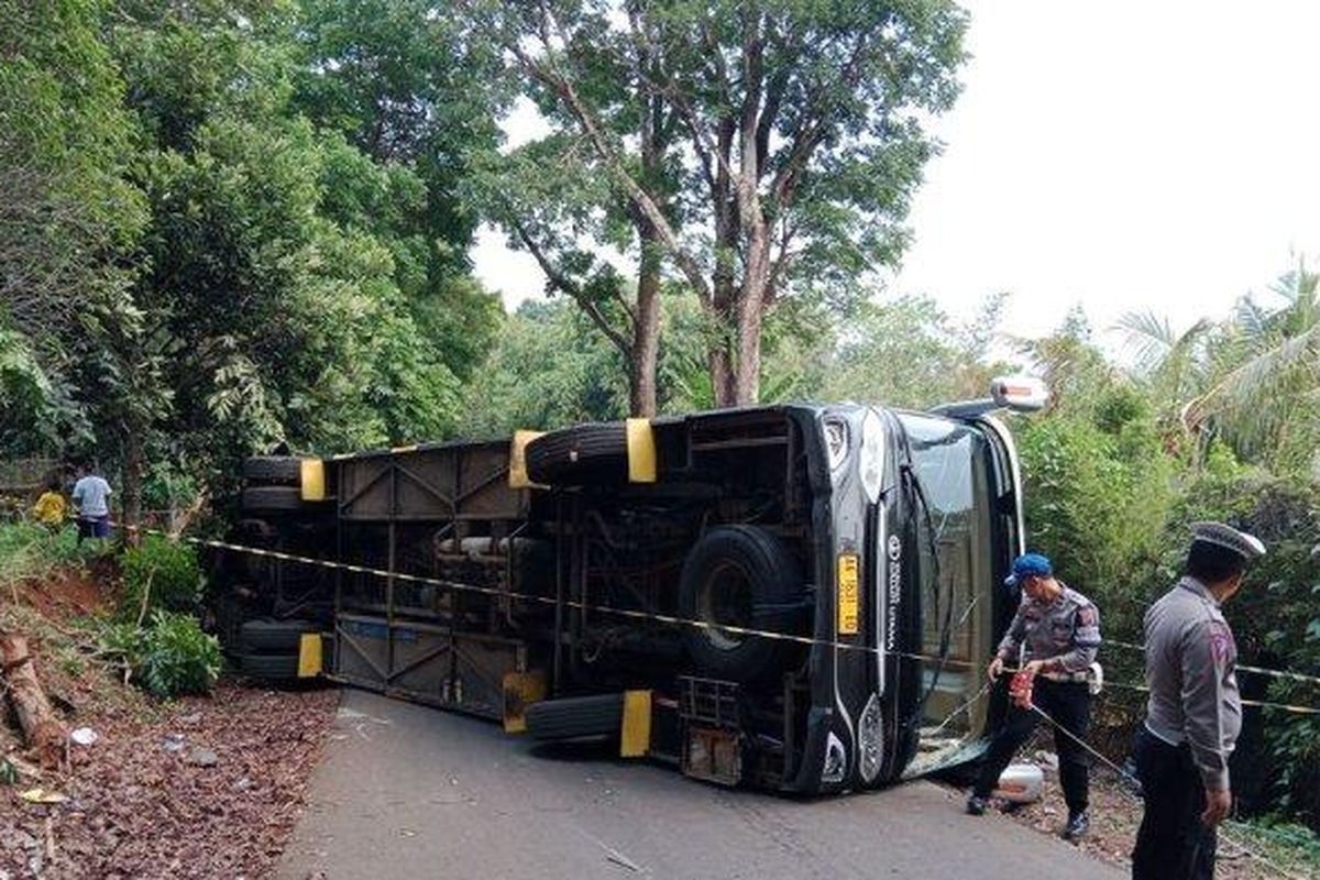 Sebuah bus pengangkut rombongan pramuka dari Kabupaten Ciamis, terguling di area Bumi Perkemahan Kiara Payung, di Dusun Cikeuyeup, Desa Sindangsari, Kecamatan Sukasari, Sumedang, Minggu (24/12/2023). (TRIBUNJABAR.ID/KIKI ANDRIANA)