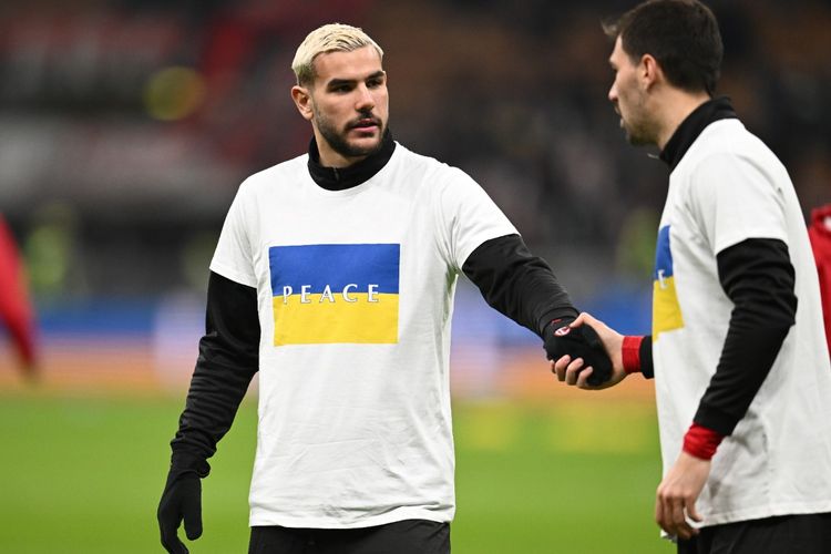 Theo Hernandez dan Alessio Romagnoli mengenakan kaus khusus sebagai bentuk dukungan untuk Ukraina yang dilanda konflik dengan Rusia selama pemanasan menjelang duel melawan Inter Milan pada semifinal Coppa Italia. 