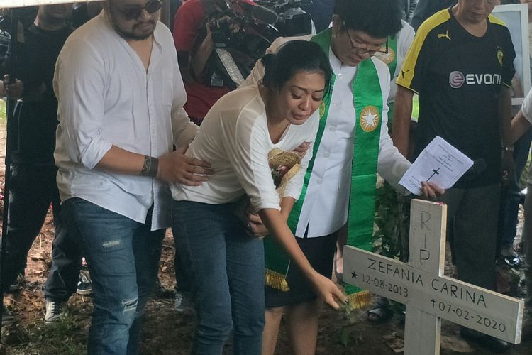 Karen Pooroe didampingi kerabat dan pendeta saat menabur bunga di pemakaman anaknya, di TPU Tanah Kusir, Bintaro, Jakarta Selatan, Minggu (9/2/2020)