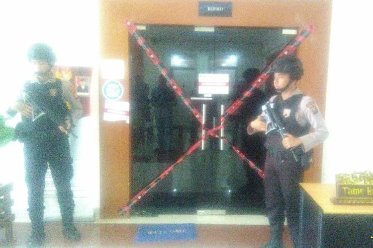 Dua orang polisi bersenjata lengkap berjaga di depan ruang kerja Bupati Muara Enim Ahmad Yani pasca peristiwa OTT oleh KPK selasa dini hari