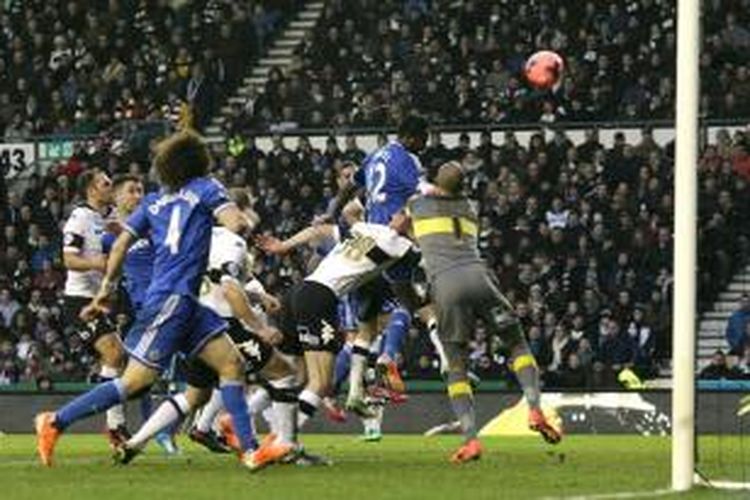 Gelandang Chelsea, Jhon Obi Mikel (12), menyundul bola ke gawang Derby County yang gagal diantisipasi kiper Lee Grent, dalam  pertandingan putaran ketiga Piala FA, di Stadion iPro, Derby, Minggu (5/1/2014). Dalam laga tersebut, Chelsea menang 2-0 lewat gol yang dicetak oleh Jhon Obi Mikel dan Oscar.