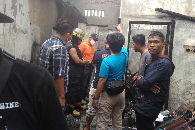 Petugas memadamkan api yang membakar sebuah rumah di Jalan Kenari Raya II, Perumnas Mandala, Deli Serdang pada Sabtu (26/2/2022) siang. Dalam peristiwa itu, seorang ibu dan dua orang anaknya ditemukan tewas dengan kondisi hangus terbakar di kamar mandi.