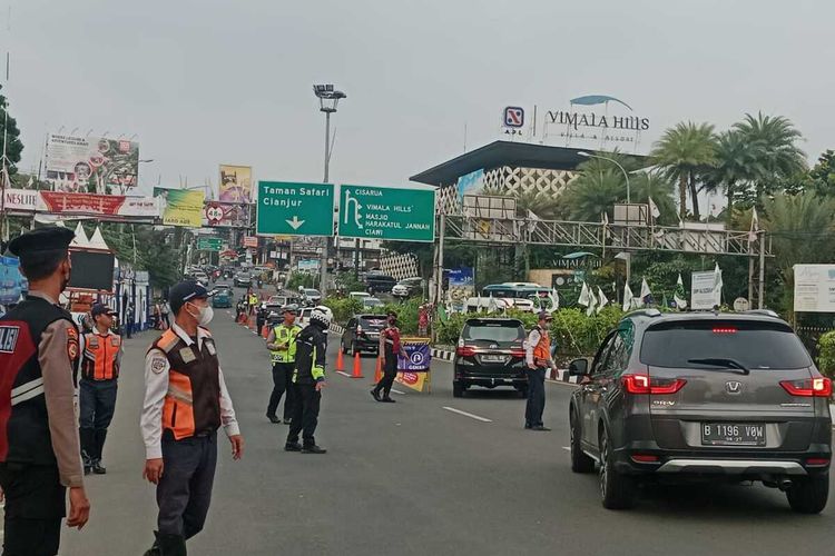 Petugas sedang menerapkan sistem ganjil genap di pintu masuk Puncak Bogor atau tepatnya di Simpang Gadog, Jalan Ciawi, Sabtu (29/4/2023) petang.