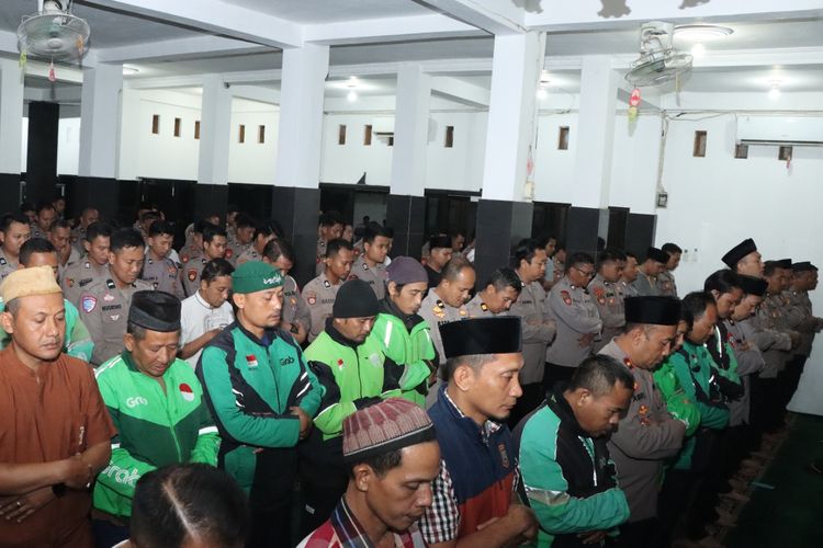 Komunitas Ojol di Kabupaten Nganjuk, Jawa Timur, bersama polisi saat melaksanakan salat gaib dan pembacaan tahlil untuk almarhum Affan Kurniawan di Masjid Al Ikhlash Polres Nganjuk, Jumat (29/8/2025) malam