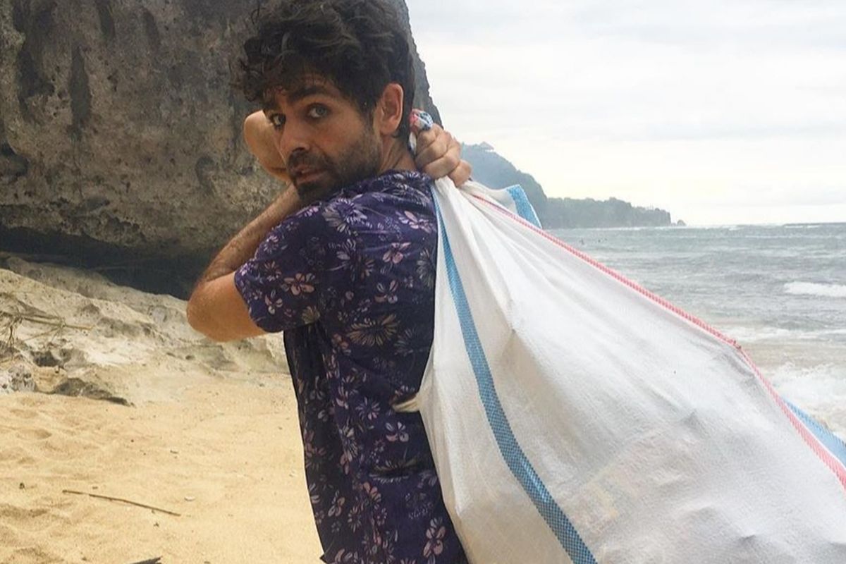 Aktor Hollywood Adrian Grenier yang dikenal sebagai bintang serial Entourage, saat membersihkan sebuah pantai di Bali dari sampah.