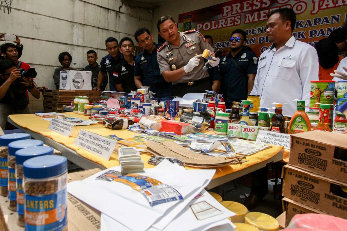 Kapolres Metro Jakarta Barat, Kombes Hengki Haryadi (tengah) saat menunjukan barang bukti pada rilis kasus makanan kedaluwarsa di Jalan Kalianyar I, Tambora, Jakarta, Selasa (20/3/2018). Para pelaku mengubah label makanan dengan alat agar tampak seperti baru, kemudian makanan tersebut dipasarkan ke daerah-daerah.