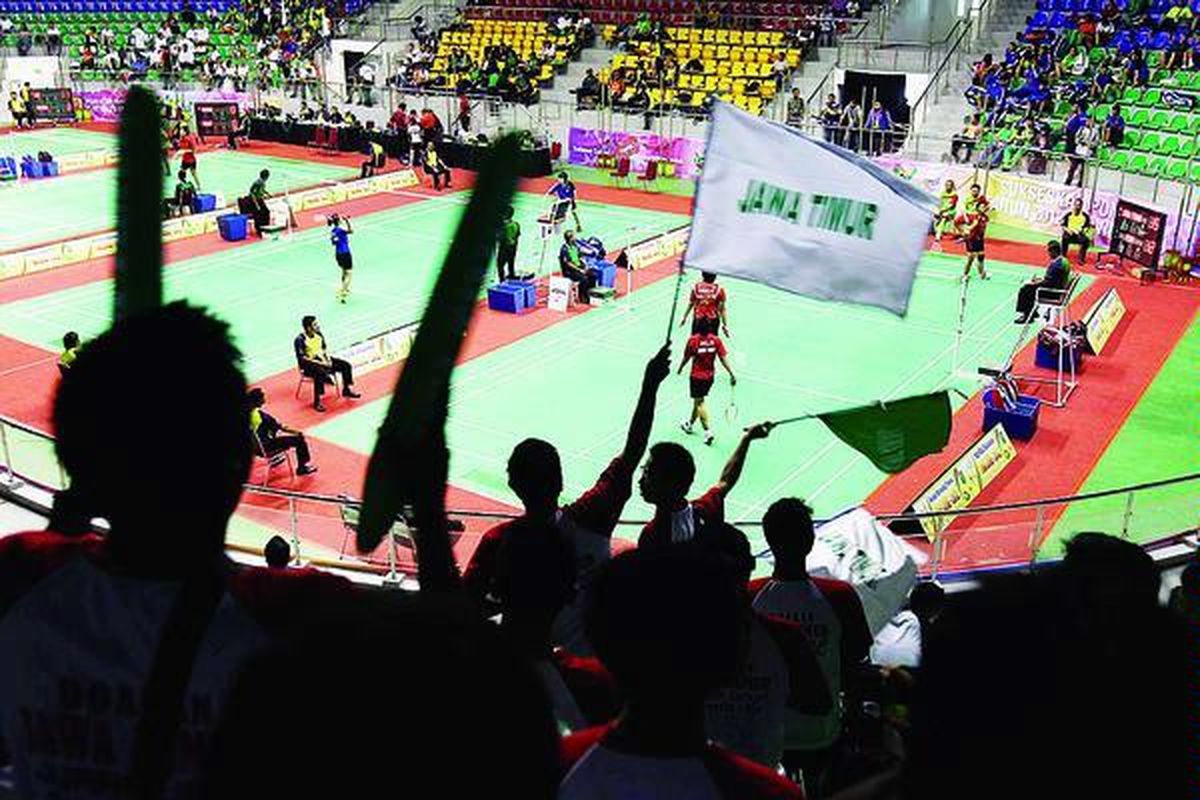 Suporter tim Jawa Timur memberi dukungan kepada para pemain saat melawan Riau di babak penyisihan nomor beregu bulu tangkis putri PON XVIII di Gelangggang Remaja Pekanbaru, Riau, Minggu (9/9).