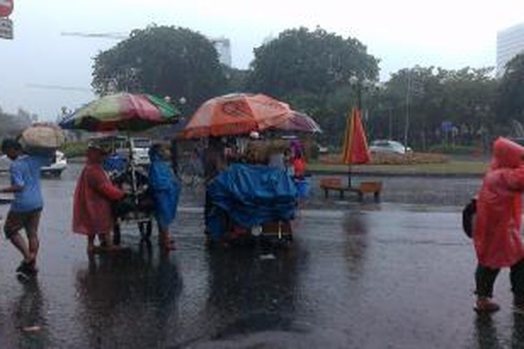 PKL di Monas lari tunggang langgang dirazia Satpol PP di tengah hujan deras, Jumat (26/12/2014).