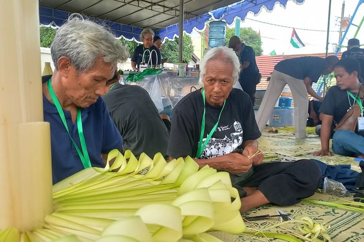 Sejumlah orang sedang merangkai janur menjadi ornamen-ornamen dhaup ageng di sekitar Pura Pakualaman, Senin (8/1/2024)