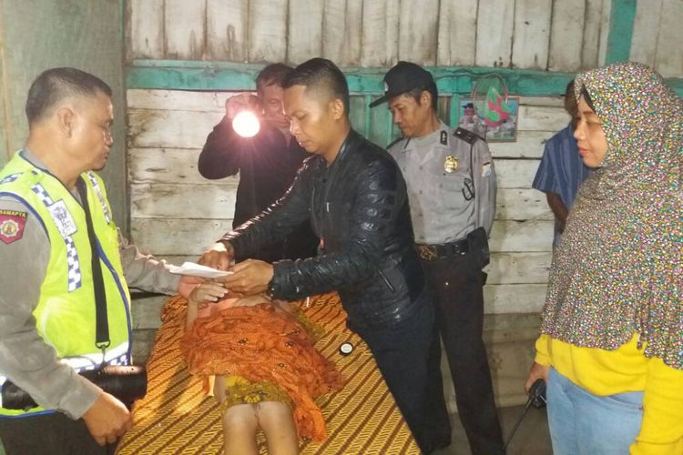 Petugas melakukan visum terhadap salah satu korban tenggelam di Sungai Bangunrejo Kidul, Kecamatan Kedunggalar, Kabupaten Ngawi, Senin (12/6/2017) malam. 