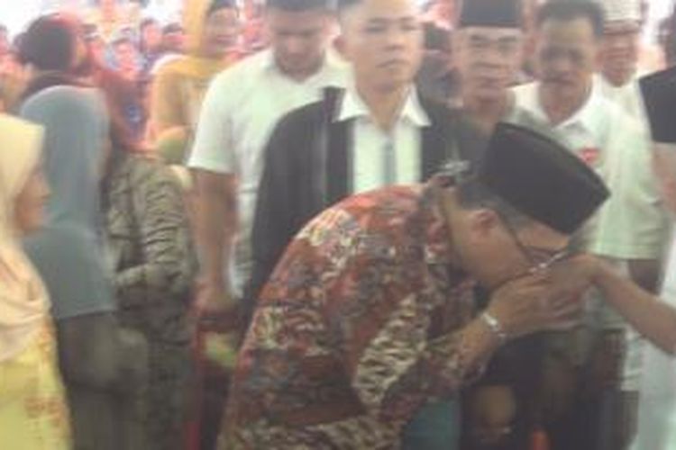 helmy yahya menyium tangan warga desa muara penimbung dalam kegiatan kampanye pencalonan dirinya sebagai bupati ogan ilir