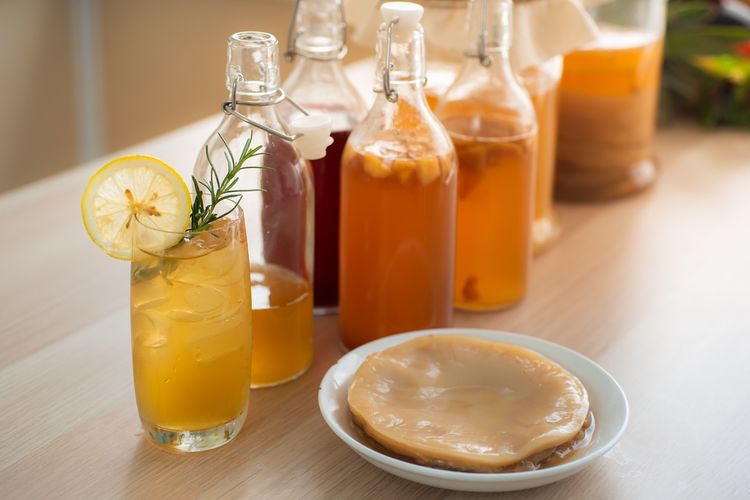 Ilustrasi scoby (kanan) dengan botol berisi kombucha. 