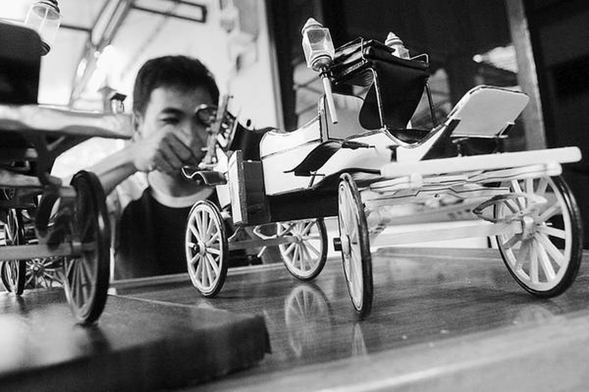 David (27) mengerjakan miniatur kereta Keraton Yogyakarta dari limbah kayu pinus di Kelurahan Wedomartani, Kecamatan Ngemplak, Kabupaten Sleman, DI Yogyakarta, Selasa (24/2). Pembuatan satu miniatur kereta membutuhkan waktu tiga hari, dan dikerjakan dua pekerja. Miniatur kereta Keraton Yogyakarta, seperti kereta Kiai Roto Biru, Kiai Jongwiyat, serta Manik Retno, tersebut dijual dengan harga Rp 300.000-Rp 360.000 per buah.  