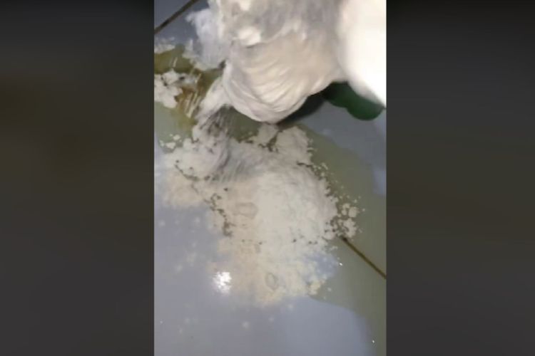 Tangkapan layar video cara membersihkan minyak goreng yang tumpah menggunakan tepung terigu.