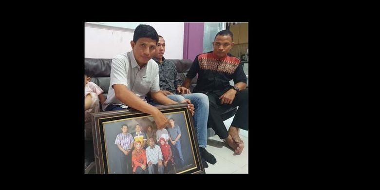 Abang kandung Irfan Suri, Akhyar Tarfi (kiri) dan Letkol Muhammad Ridha (kanan) menunjukkan foto Letkol Irfan Suri, putra asli Aceh yang termasuk salah satu kru di kapal selam KRI Nanggala-402, di kediaman mereka di Banda Aceh, Sabtu (24/4/2021). 