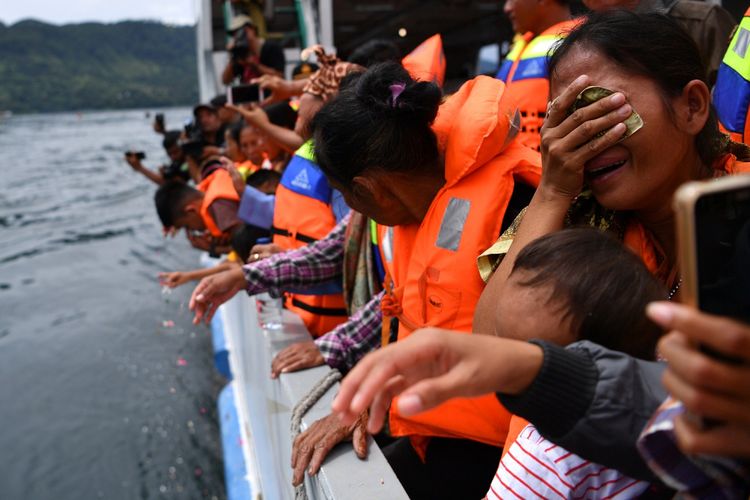 Keluarga korban tenggelamnya KM Sinar Bangun menangis saat prosesi tabur bunga di kawasan titik tenggelamnya kapal di Danau Toba, Sumatera Utara, Senin (2/7). Operasi SAR gabungan pencarian korban KM Sinar Bangun akan selesai pada Selasa 3 Juli 2018 sementara itu 164 korban masih dinyatakan hilang. ANTARA FOTO/Sigid Kurniawan/aww/18.