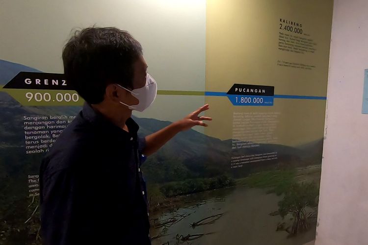 Seorang pemandu di Museum Sangiran menjelaskan informasi tertulis seputar asal mula kawasan Sangiran dari lautan menjadi daratan.