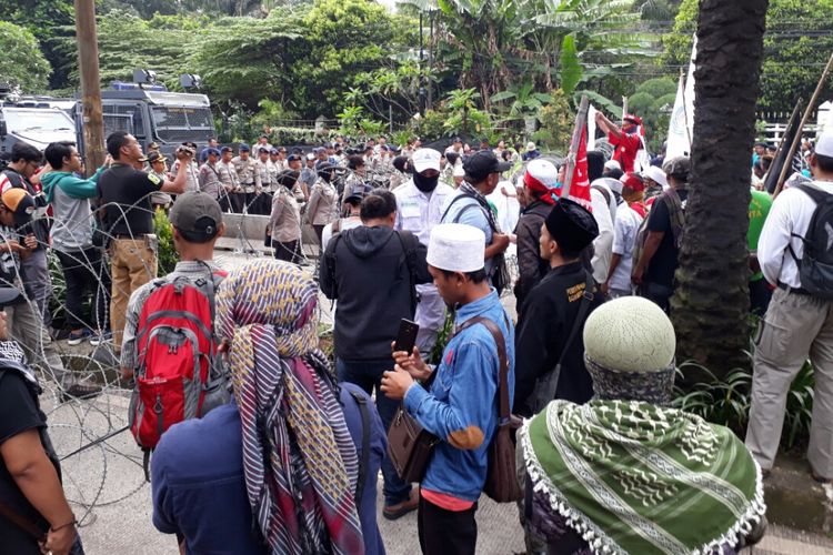 Massa kontra Ahok di Jalan RM Harsono, Jakarta Selatan, bereaksi mendekati kawat berduri saat mendengar penundaan pembacaan tuntutan di sidang Ahok, Selasa (11/4/2017)