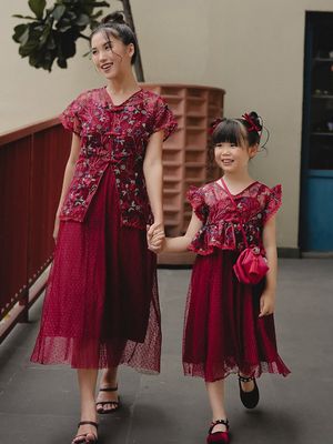 Model menggunakan cheongsam brokat merah maroon.