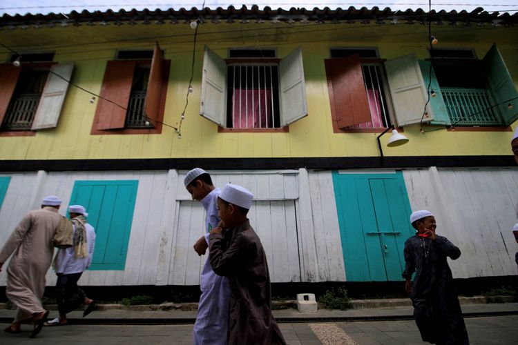 Warga Palembang keturunan Arab pulang seusai menjalankan ibadah Sholat Idul Fitri di Musholah Kampung Al-Munawar, Kecamatan Seberang Ulu II, Palembang, Sumatera Selatan, Minggu (25/6/2017).