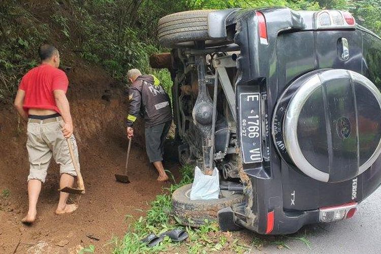 Sejumlah warga saat menutup saluran air untuk mengevakuasi mobil yang terguling di jalur Cikebo, Kecamatan Maja, Kabupaten Majalengka, Selasa (30/4/2024). 
