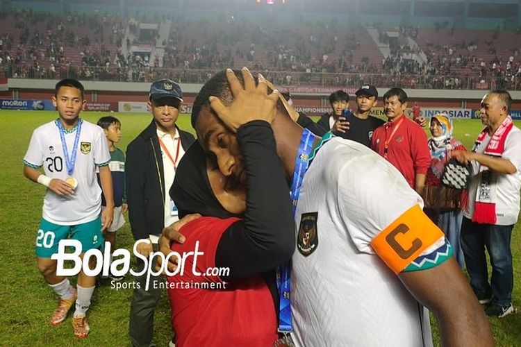 Kapten timnas U16 Indonesia, M. Iqbal Gwijangge, bersama ibu, Besinah Haluk, seusai laga final Piala AFF U16 2022 yang dihelat di Stadion Maguwoharjo, Jumat (12/8/2022) malam WIB. Timnas U16 Indonesia sukses meraih gelar juara Piala AFF U16 2022 setelah melibas Vietnam 1-0.