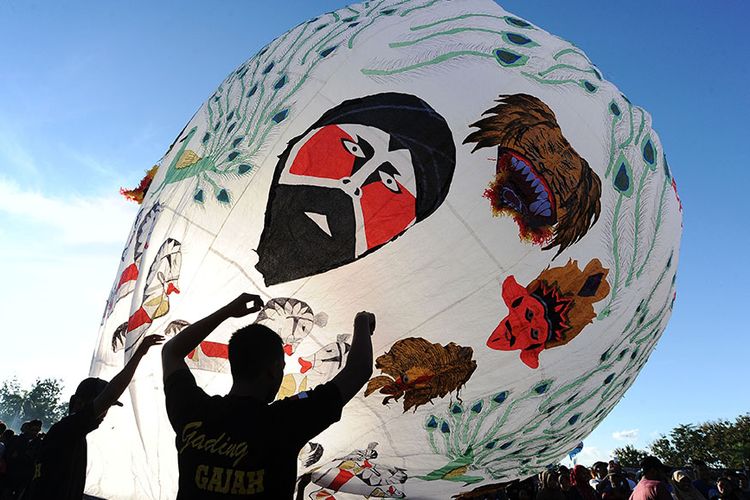 Warga menerbangkan balon udara saat mengikuti Festival Balon Ponorogo 2019 di Desa Nongkodono, Ponorogo, Jawa Timur, Rabu (12/6/2019). Festival balon yang digelar Kementerian Perhubungan bekerja sama dengan AirNav Indonesia, kepolisian, dan pemerintah daerah setempat tersebut dilakukan untuk mensosialisasikan dan melestarikan tradisi balon udara yang aman dengan cara ditambatkan menggunakan tali untuk meminimalisir penerbangan balon udara secara liar yang dapat membahayakan keselamatan penerbangan.