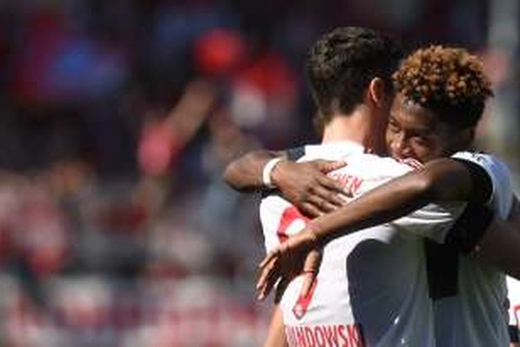 Bek Bayern Muenchen, David Alaba (kanan), memeluk striker Robert Lewandowski setelah mencetak gol kedua Bayern ke gawang FC Ingolstadt 04 pada pertandingan Bundesliga di Audi Sportpark, Ingolstadt, Sabtu (7/5/2016).