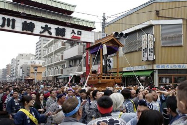 Orang-orang yang bersuka ria membawa kuil portabel dengan lingga besi besar melalui jalan selama Kanamara Matsuri, atau Festival Lingga Baja, di Kawasaki, Jepang, pada 3 April 2016. Festival, diadakan setiap tahun pada hari Minggu pertama di bulan April  , merayakan kesuburan dan kesehatan seksual. 