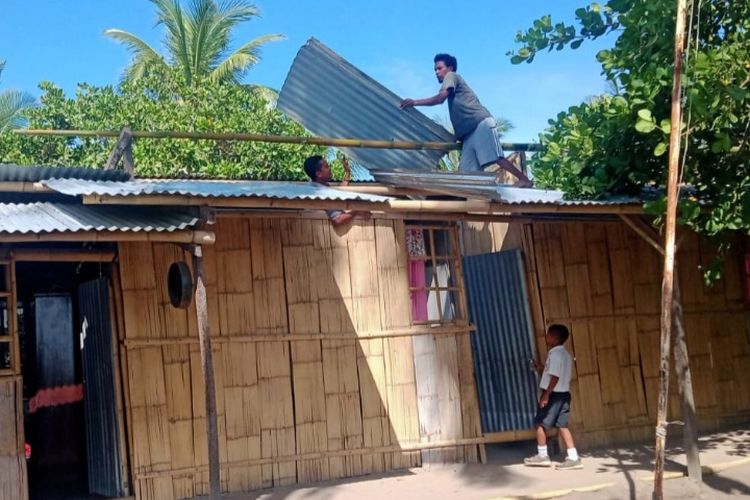 Foto: Warga sedang memperbaiki atap gedung SDN Oka di Dusun Loimite, Desa Ladolaka, Kecamatan Palue, Kabupaten Sikka, Nusa Tenggara Timur (NTT) yang jebol akibat diterjang angin puting beliung, Selasa (8/11/2022).