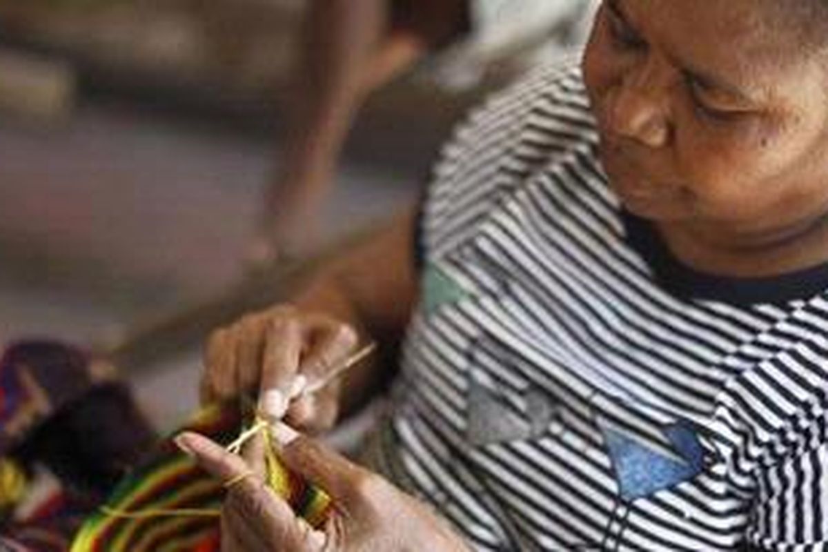 Mama Yuliana merajut tas khas Papua yang biasa disebut noken di Pasar Hamadi, Jayapura, Provinsi Papua, Selasa (21/9/2010). Tas tersebut selesai dikerjakan dalam sehari dan dijual Rp 100.000 per buah.