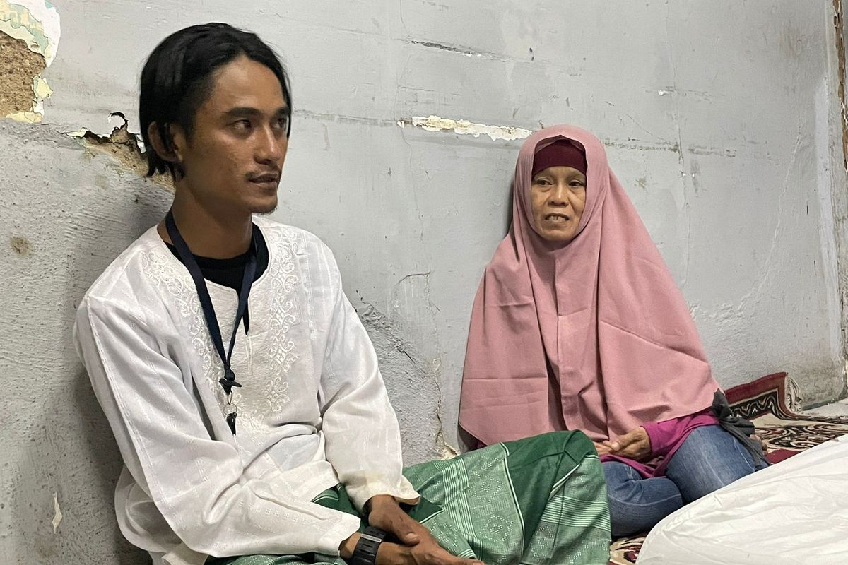 Dizto Indianto (28) bersama ibundanya, Tahiyat (53), saat bercerita mengenai ayahnya, Zubaidi (54) yang meninggal dunia saat bertugas mengurus logistik pemilihan umum (pemilu) 2024 di GOR Matraman, Jakarta Timur, Selasa (13/2/2024). 