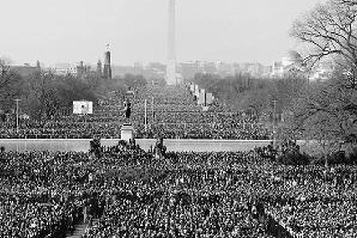 Massa berkumpul di lapangan di depan Capitol Hill, Washington, pada pelantikan Barack Obama sebagai presiden ke-44 AS, Selasa (20/1) di Washington. Monumen Washington terlihat di latar belakang.