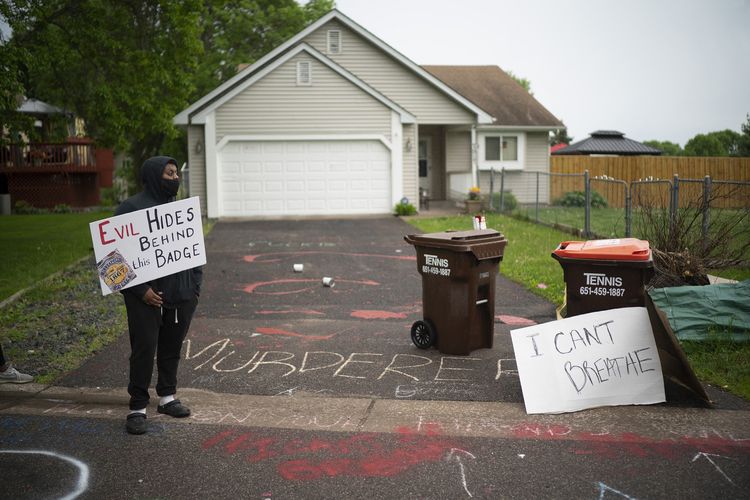 Demonstran mencoreti rumah Derek Chauvin, polisi pembunuh George Floyd, dengan tulisan-tulisan makian. Seorang demonstan juga terlihat membawa papan bertuliskan Orang Jahat di Balik Lencana pada Rabu (27/5/2020).
