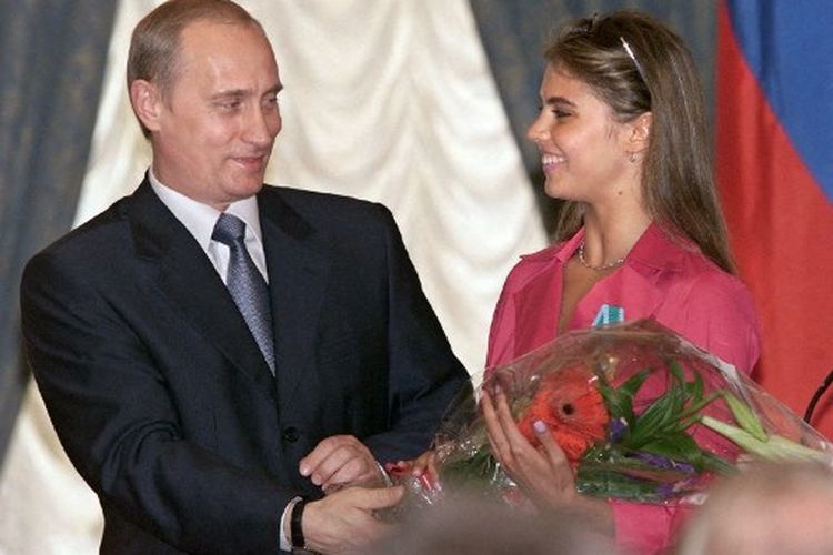 Presiden Rusia Vladimir Putin (kiri) menyerahkan bunga kepada Alina Kabayeva, bintang senam ritmik Rusia dan pemenang hadiah Olimpiade, setelah menganugerahinya Order of Friendship selama upacara penghargaan tahunan di Kremlin 08 Juni 2001. 