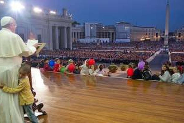 Seorang anak berlari ke panggung dan memeluk Paus Fransiskus saat Pemimpin Tertinggi Gereja Katolik Sedunia itu berkhotbah di depan kerumunan massa di alun-alun St Petrus di Vatican City, beberapa waktu lalu. (Dokumentasi)