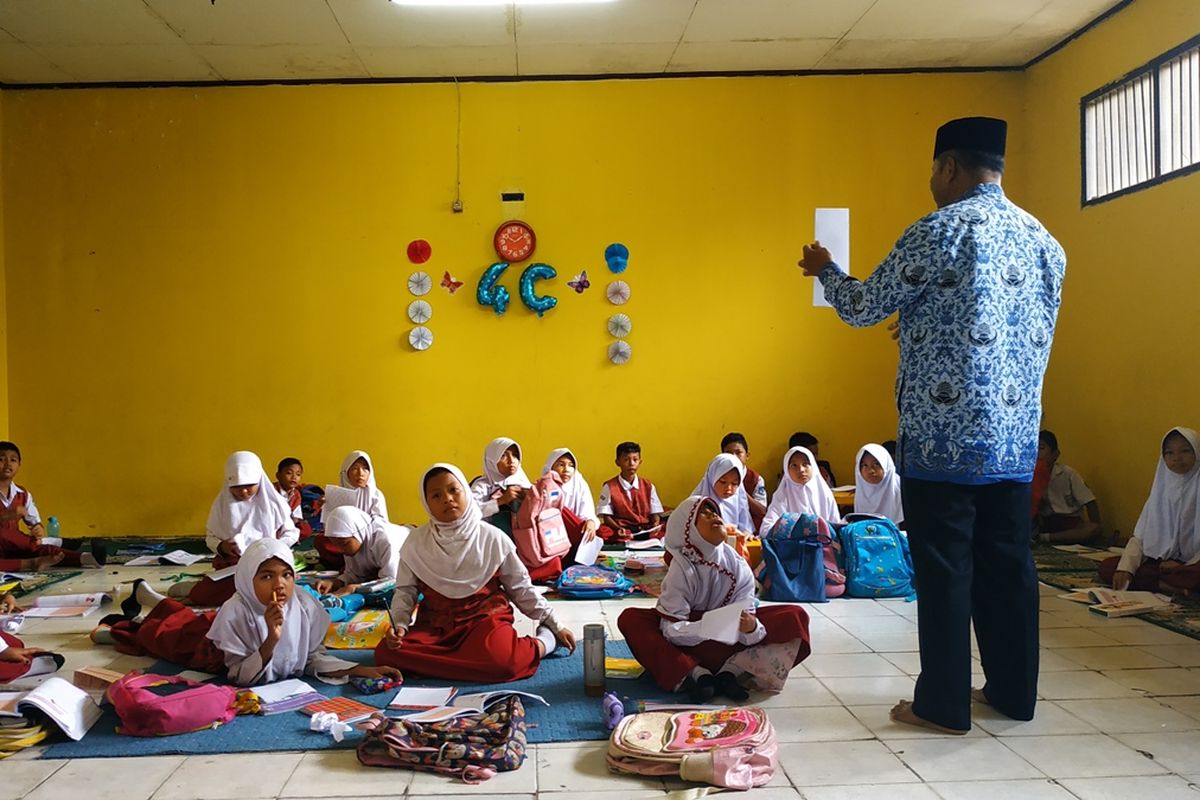 Murid SDN Jatimulya 09 Tambun Selatan, Kabupaten Bekasi belajar di kelas dengan duduk di lantai karena sekolahnya belum kebagian meja-kursi, Selasa (17/9/2019).