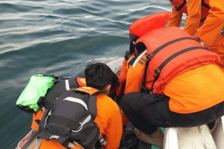 Petugas saat menarik korban dari perairan Danau Toba, Rabu (20/6/2018).