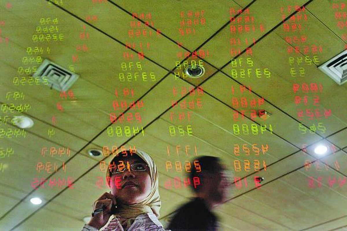 Nasabah mengamati pergerakan harga saham melalui papan informasi elektronik di galeri Mandiri Sekuritas, Jakarta.