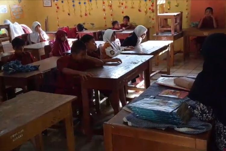 Siswa SDN Karawang Kulon 1 mengikuti kegiatan belajar mengajar (KBM) dengan lantai tergenang air banjir, Kamis (30/1/2025) pagi.