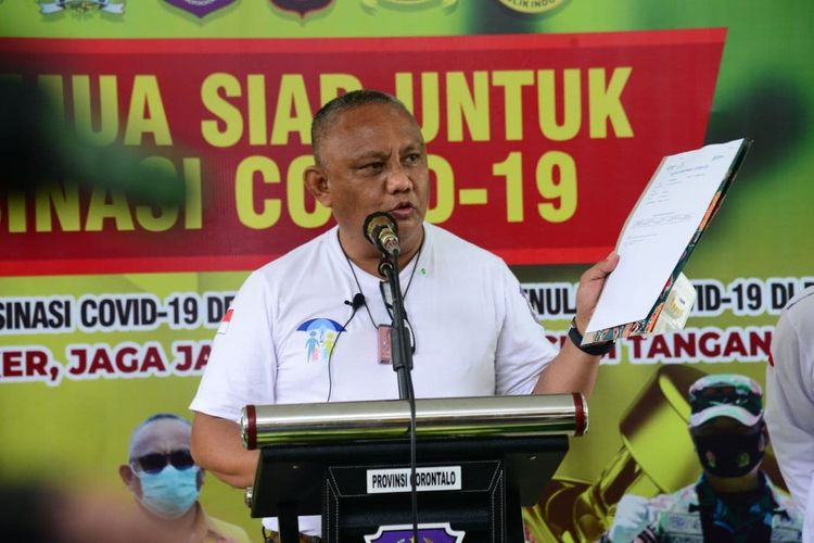 Gubernur Gorontalo Rusli Habibie memperlihatkan surat keterangan mengikuti vaksinasi Covid-19. Surat keterangan ini diusulkan menjadi syarat bepergian ke luar kota selain rapid antigen atau swab.